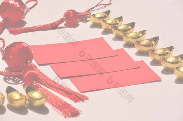 春节装饰品或红包、金锭或粉色背景的金块。汉译英：好运、好运、财富和资金流动. 