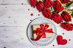 浪漫的餐桌。情人节或母亲节的爱的概念，结婚餐具。一束新鲜的勃艮第玫瑰，喜庆的礼物，旧木桌