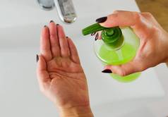 妇女在水龙头下用肥皂洗手，浴室用水.