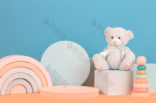 幼儿玩具背景。五彩缤纷的木制玩具、玩具熊和多色背景的几何形状讲台平台