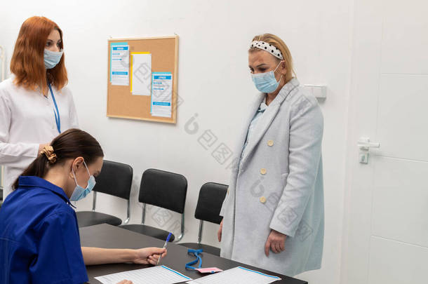 诊所入口处的<strong>医护</strong>人员会记录病人的个人资料及体温测量结果