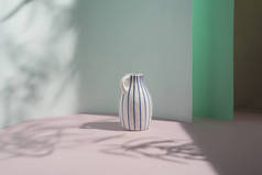 白色复古花瓶，蓝色条纹，背景柔和，叶影斑斑。室内设计版权，杂志框架。审美现代最小设计概念.