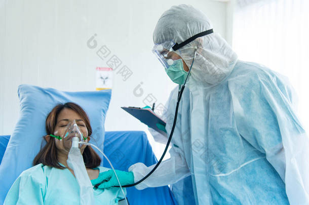 穿着防护服的医生检查病人脉搏和血氧.感染CORONA VISRUS或COVID-19的病人在医院的隔离室.