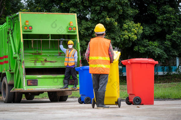 垃圾收集服务、穿着制服的垃圾清洁工人携手合作，把垃圾倒空，再用卡车装运废物及垃圾桶作垃圾处理。废物回收概念.