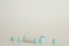 白色大理石讲台，白色背景上有蓝色装饰元素。产品的软垫,化妆品的展示.创意模拟了。化妆品的装饰或平台.