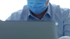 医院办公室的医生，带着面具和防护手套，用笔记本电脑