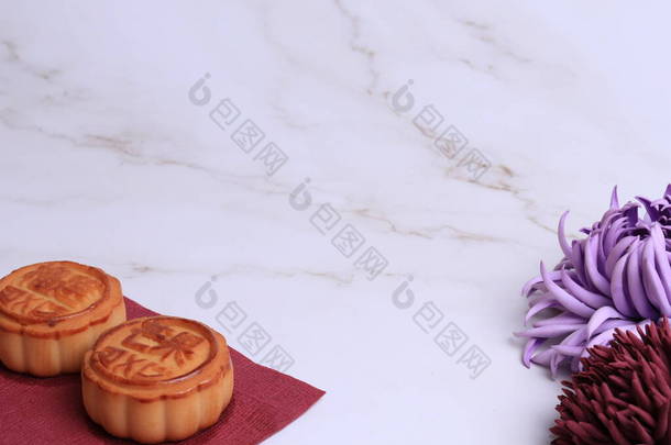 白色大理石背景上的中国月饼和菊花是秋天的象征。亚洲传统的<strong>中秋节</strong>。象形文字的翻译：芒果、石榴和荷花
