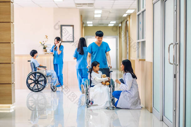拥有统一服务听诊器的专业医生小组帮助支持与坐轮椅的小女孩进行讨论和咨询，并在医院查阅相关信息