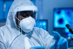 身穿防护服的非裔美国医生正在一个现代实验室进行科学实验和疫苗研发。实验室助理工作。科学和医学的概念.