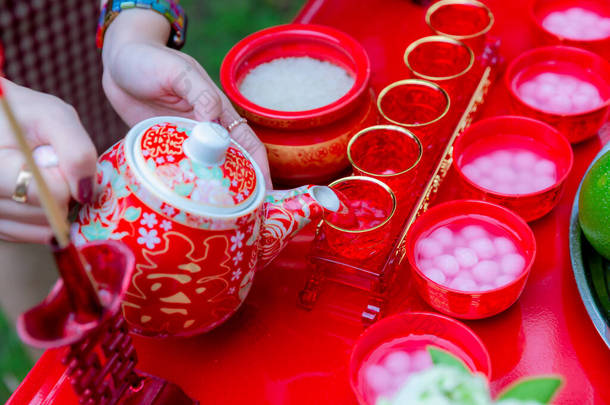 传统的中国茶具在结婚日举行。在中国婚礼上倒茶。照片中的中文文字读作双喜，翻译快乐，快乐倍增. 
