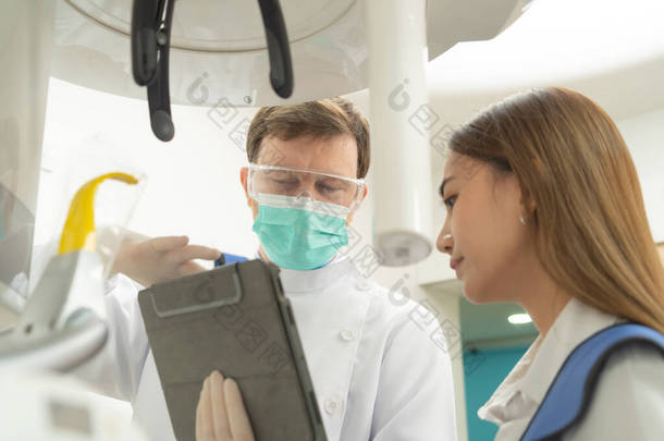 作为一个高加索牙医，人们在平板技术装置上向病人展示<strong>牙科</strong>X射线。牙齿检查。医生。<strong>牙科</strong>、医疗和<strong>牙科</strong>保健.