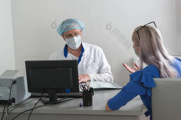 一位身穿白衣、戴着面具、头戴<strong>帽子</strong>的<strong>医生</strong>与一位病人坐在办公室的桌旁，讨论治疗方案。协商招待会。生活方式