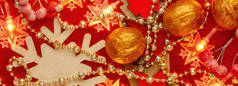 班纳红色和金色背景与圣诞装饰和花环。摘要圣诞节图案。在新年的华丽装饰上，闪耀着金色的珠子和星形的黄色花环。平躺在床上.