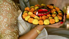 在Diwali的时候，女人用双手拿着红色的Diya灯或浅色的thali灯，它有火焰.