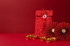 中国新年装饰比红色背景。传统的农历新年红包，金锭，纸扇