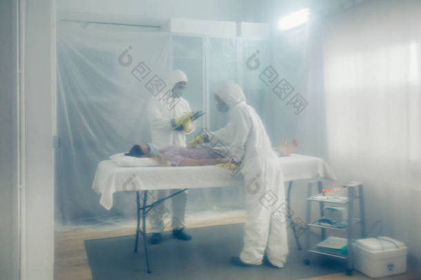 细菌学保护领域的医生对躺在轮床上的病人进行医学检查