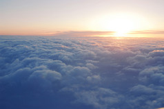 从飞机窗上俯瞰云层上方日落的壮观景象