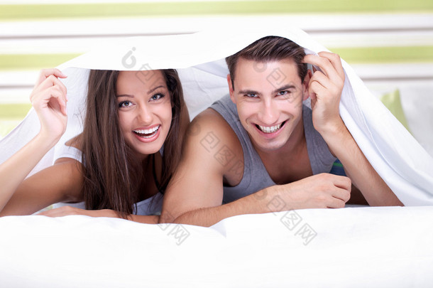年轻情侣在床单下玩