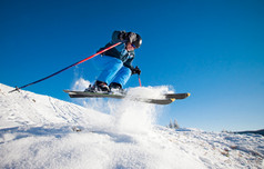 在阳光灿烂的日子里练习极速滑雪的人