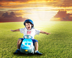 快乐的孩子在绿色草地上驾驶一辆车上