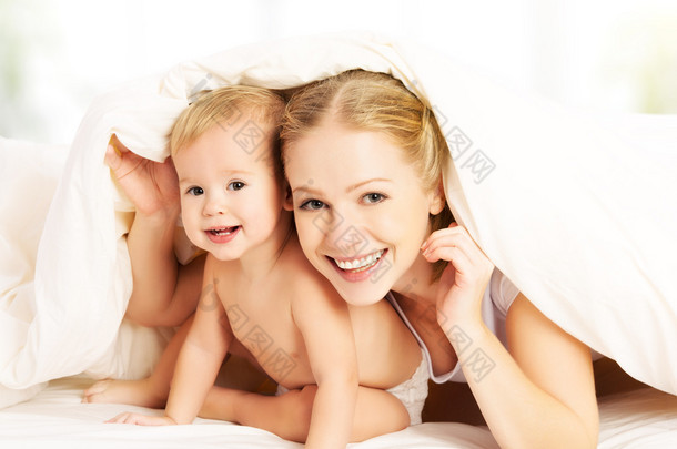 快乐家庭<strong>母</strong>亲和<strong>婴儿</strong>在床上的毯子