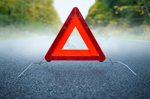 谨慎雾-雾的道路上三角警示牌