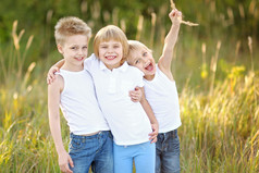三个孩子在夏天的草地上玩耍