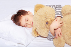 一个男孩着泰迪熊睡觉的肖像