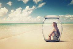 看海景海滩上一个玻璃罐子里的女人
