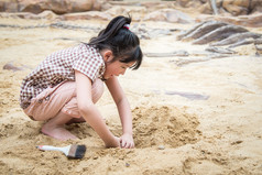 小亚洲女孩玩得开心挖沙子 