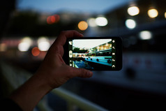 手与智能手机拍摄夜晚的城市