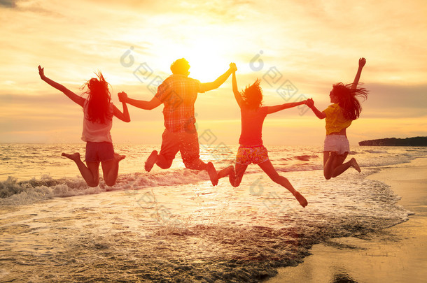 一群快乐的年轻人在海滩上跳跃