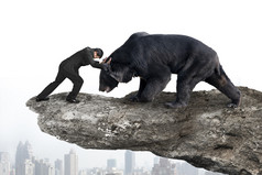 Businessman fighting against black bear on cliff with sky citysc