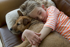 年轻的女孩和她的狗在家里拥抱