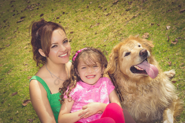 母亲、 女儿和<strong>金毛</strong>狗坐在屋外笑、 享受公园环境