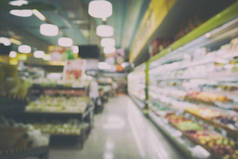 模糊的抽象背景的人在与杂项产品在货架上的超市购物