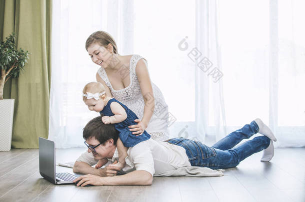 家庭的妈妈、 爸爸和女儿一起在家里 hap 的笔记本电脑