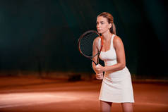 年轻的女子在一个网球场