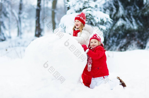 孩子们建设雪人。孩子们在雪地里。冬天的乐趣.