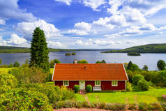 传统的红色小屋在湖在瑞典