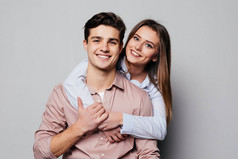 一个欢快的年轻夫妇拥抱的肖像, 而站在和看着在灰色摄像头