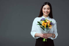 美丽的亚洲女人捧着鲜花, 微笑着在镜头上的灰色隔离