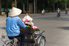 河内街上的自行车司机戴着锥形的帽子