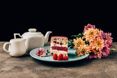 美味的蛋糕与覆盆子, 美丽的花朵和水壶与瓷壶