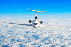 乘客飞机与三引擎在尾巴飞行在飞行水平高在天空之上云彩和蓝色天空。直接在前面查看, 正好.