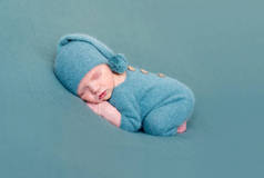 婴儿男孩裸脚穿着羊毛服装睡觉