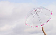 无法辨认的人的手持有透明的雨伞, 对天空充满云。气象学, 天气预报对象概念.