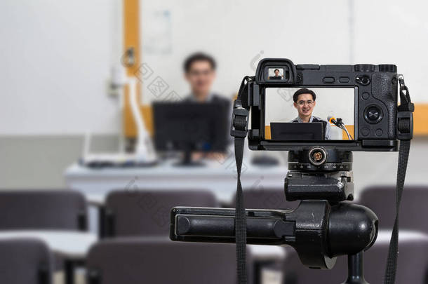 专业数码 Mirrorless 摄像机在三脚架上录制亚洲教师在课堂上的视频博客, 照相机为摄影师或视频和技术直播流概念, 大学教育