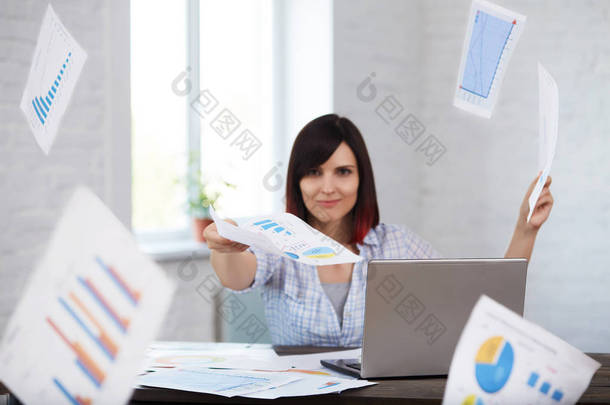 快乐和微笑的女工投掷文件在办公室与下落的文件四处走动。及时完成工作。时间管理, 期限概念.