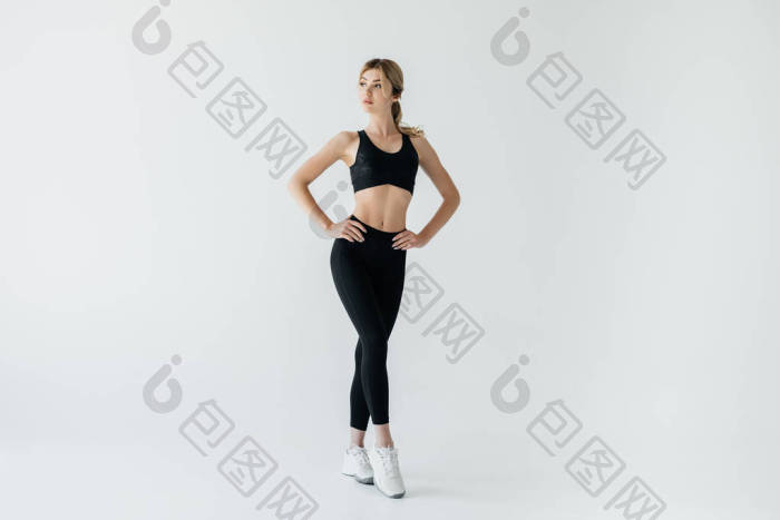 美丽的运动员叉腰黑色运动服站在灰色的孤立图片-包图网企业站